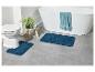 Deux tapis de bain, des toilettes et une baignoire dans une salle de bain.