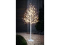 Un sapin de Noël blanc illuminé dans le jardin.
