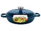 Cocotte en fonte bleue avec une coupe transversale montrant des pâtes de courgettes, tomates et pignons.