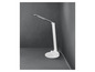 Une lampe de bureau blanche avec un bras flexible dans un coin sur un sol gris.