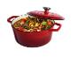 Cocotte rouge avec ragoût de bœuf et légumes, couvercle entrouvert