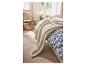 Couverture douce LIVARNO home sur un lit avec des draps bleus et blancs.