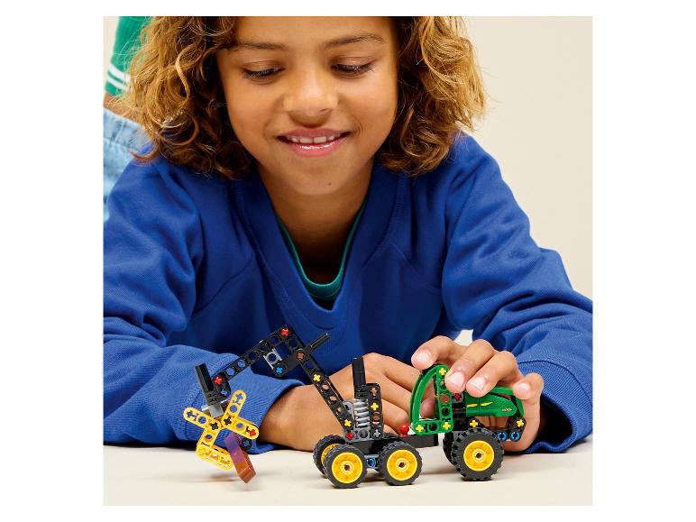 Un enfant joue avec un tracteur jouet et une pelleteuse faits de blocs de construction.