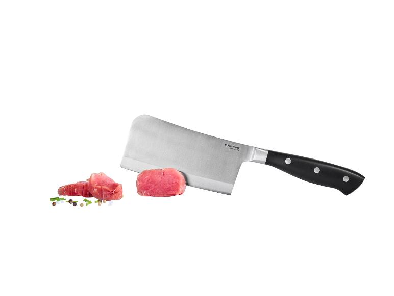 Couteau de boucher avec des morceaux de viande crue et des épices.