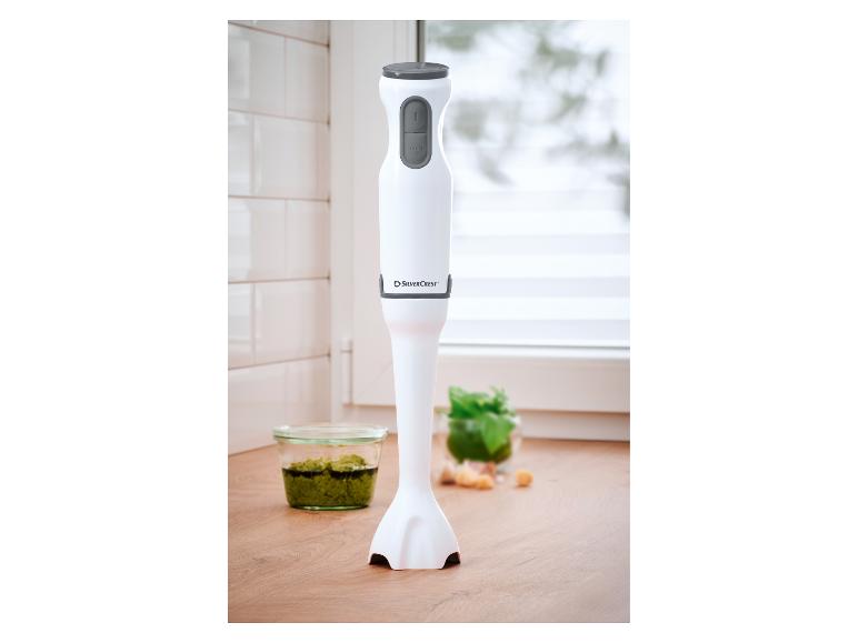 Mixeur plongeant SilverCrest blanc avec boutons gris, à côté d'un bol de pesto.