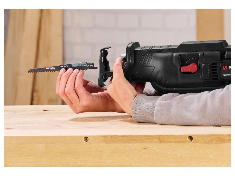 Mains insérant une lame de scie Parkside pour bois dans une scie sabre.