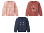 Trois jolis pulls en tricot pour enfants avec des fleurs, un chat et une fleur à paillettes.