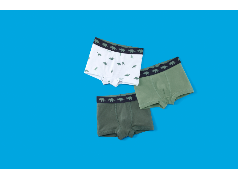 Trois boxers pour garçons, un blanc à imprimé dinosaures, deux verts à ceinture dinosaures.