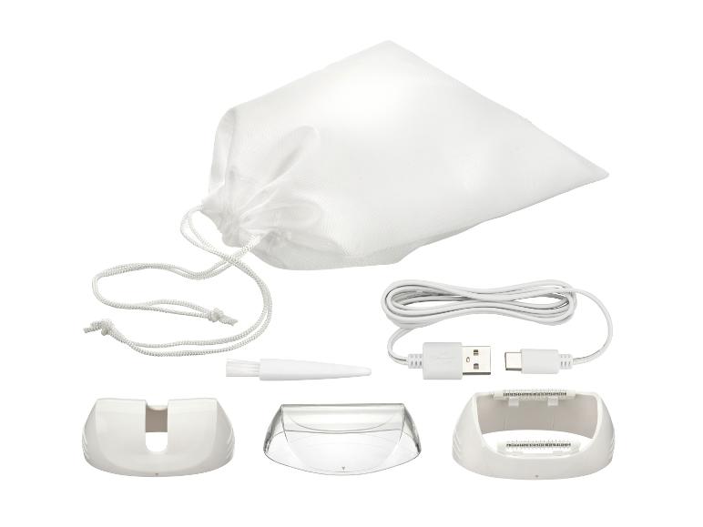Ensemble épilateur avec sac blanc, câble USB, brosse et accessoires.