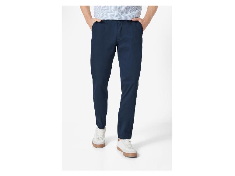 Pantalon chino bleu marine et baskets blanches.