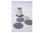 Une tasse de thé sur un dessous de verre en tricot gris.