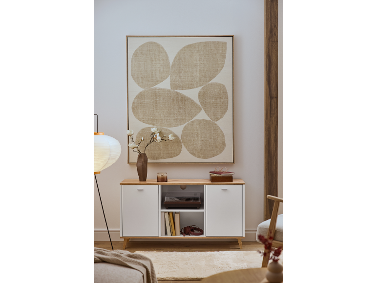 Une commode blanche avec un plateau en bois, décorée d'un tableau abstrait et d'un vase de fleurs.