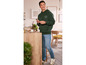 Un homme portant un sweat-shirt à capuche vert avec l'inscription 'Purpose Fuels' et un jean bleu.