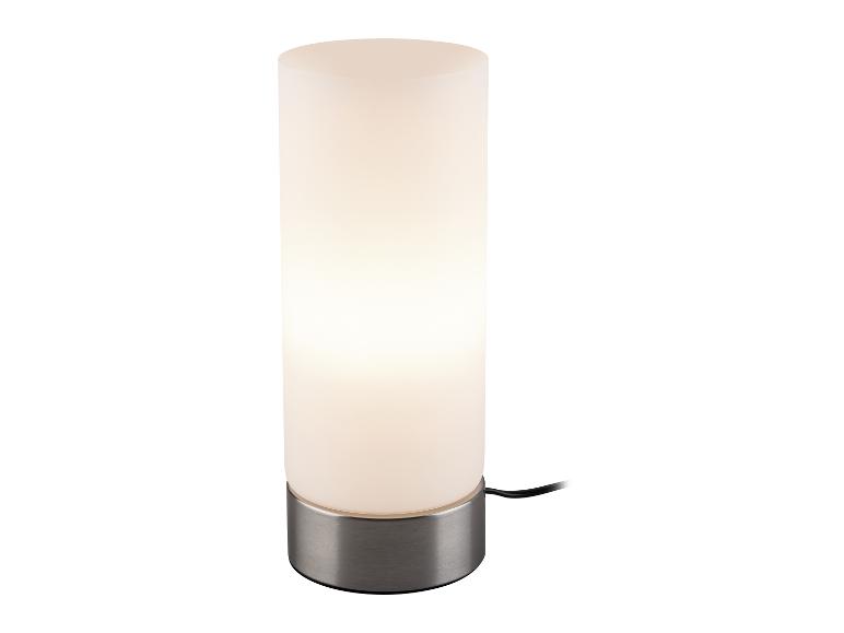 Lampe de table cylindrique éclairée avec une base en métal brossé.
