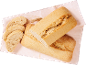 Pain ciabatta fraîchement cuit, entier et tranché, avec un épi de blé sur un tissu à carreaux.
