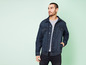 Un homme portant une veste en jean et un jean.