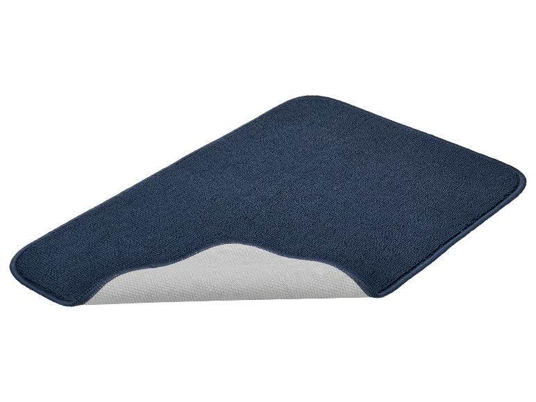 Tapis de bain bleu foncé avec dessous antidérapant, sur fond blanc.