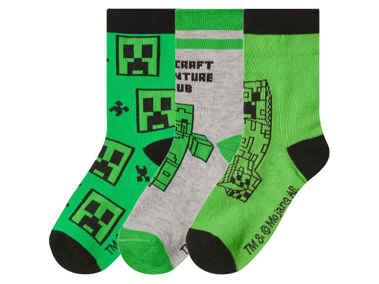Trois paires de chaussettes avec des motifs de personnages pixelisés, en vert et gris.