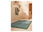 Tapis de bain bleu clair sur sol en bois.