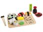 Ensemble de jeu de sushi en bois avec des rouleaux, des sauces et des baguettes.