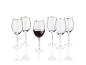 Cinq verres avec une bordure dorée, dont un rempli de vin rouge.