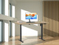 Un bureau en bois avec une hauteur réglable et un moniteur sur un bras de bureau.
