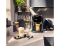 Machine à café automatique avec café et latte macchiato dans une cuisine moderne.