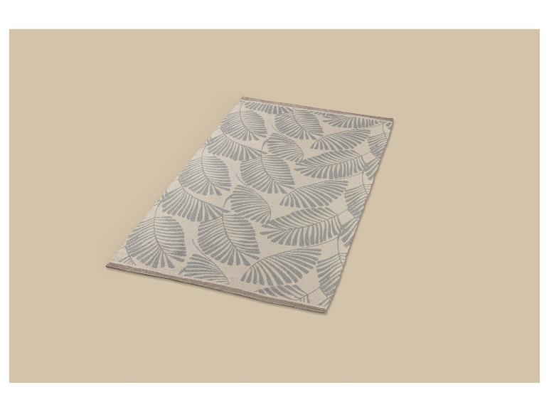Tapis rectangulaire avec un fond clair et un motif de feuilles grises.