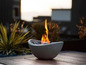 Un foyer moderne avec des flammes dans un bol en béton.