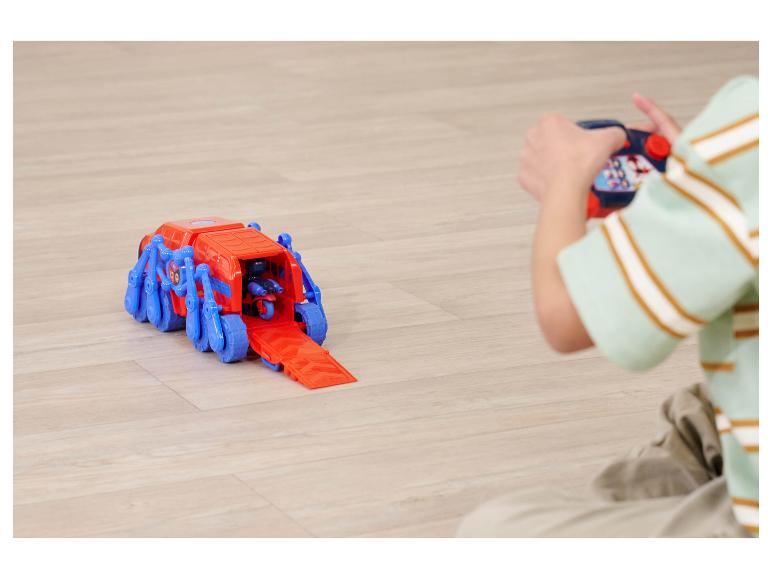 Enfant jouant avec un véhicule jouet rouge et bleu télécommandé.