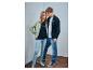 Jeune couple en jeans et vestes avec des t-shirts sur lesquels est écrit « STRENESSE BLUE »