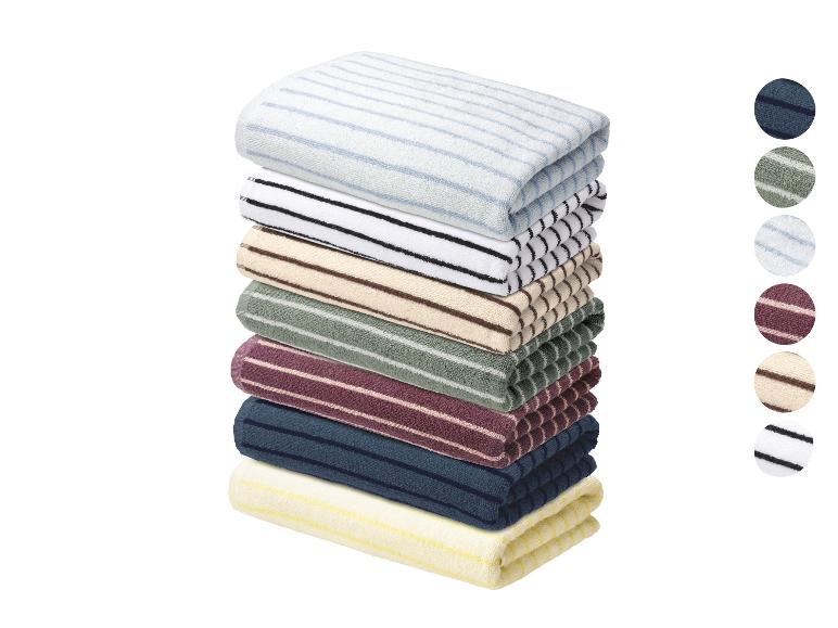 Pile de serviettes rayées de couleurs variées avec des échantillons de couleur circulaires.