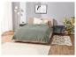 Couverture vert olive sur lit, tapis et lampes.