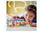 Une fille souriante joue avec un ensemble de construction coloré avec des figurines et des accessoires.