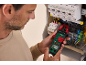 Un électricien utilise un multimètre à pince ampèremétrique Parkside pour vérifier un tableau électrique Schneider Electric.