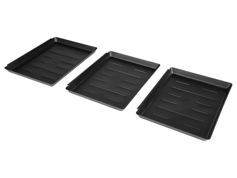 Trois plateaux de rangement en plastique noir.
