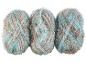 Trois pelotes de fil fantaisie bleu sarcelle, marron et blanc