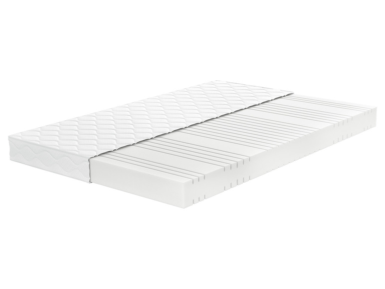 Un matelas blanc avec un noyau rayé et un dessus matelassé.