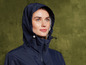 Une femme porte un imperméable bleu marine avec une capuche.