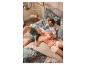 Couple en pyjama imprimé tropical se relaxant sur un lit avec une housse de couette à motifs.