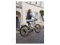 Une femme fait du vélo électrique beige en ville.