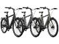 Trois vélos électriques noirs avec des détails de différentes couleurs.