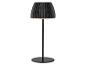 Lampe de table noire avec abat-jour plissé et base ronde, allumée.