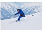Enfant portant une veste de ski bleue CRIVIT skiant sur une piste enneigée.