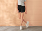 Shorts noirs et baskets blanches pour femmes.