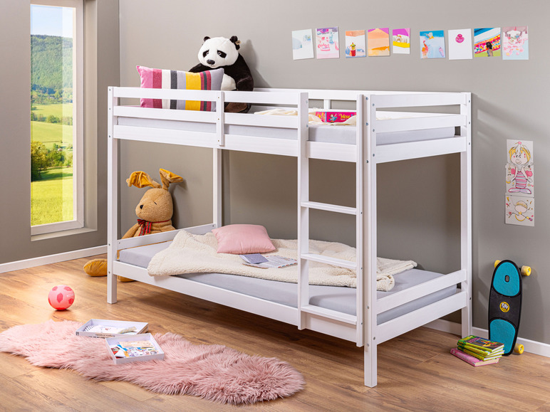 Un lit superposé en bois blanc avec des couvertures et des oreillers roses.