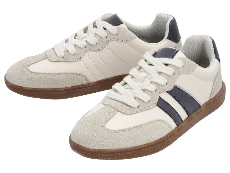 Une paire de baskets crème avec des empiècements en daim gris et des rayures bleu foncé.