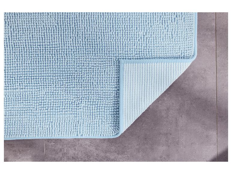 Un tapis de bain bleu clair avec une texture douce.