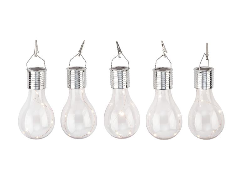 Cinq lampes solaires en forme d'ampoule, suspendues par des pinces.