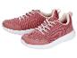 Une paire de chaussures de sport roses avec des lacets blancs et des semelles blanches.